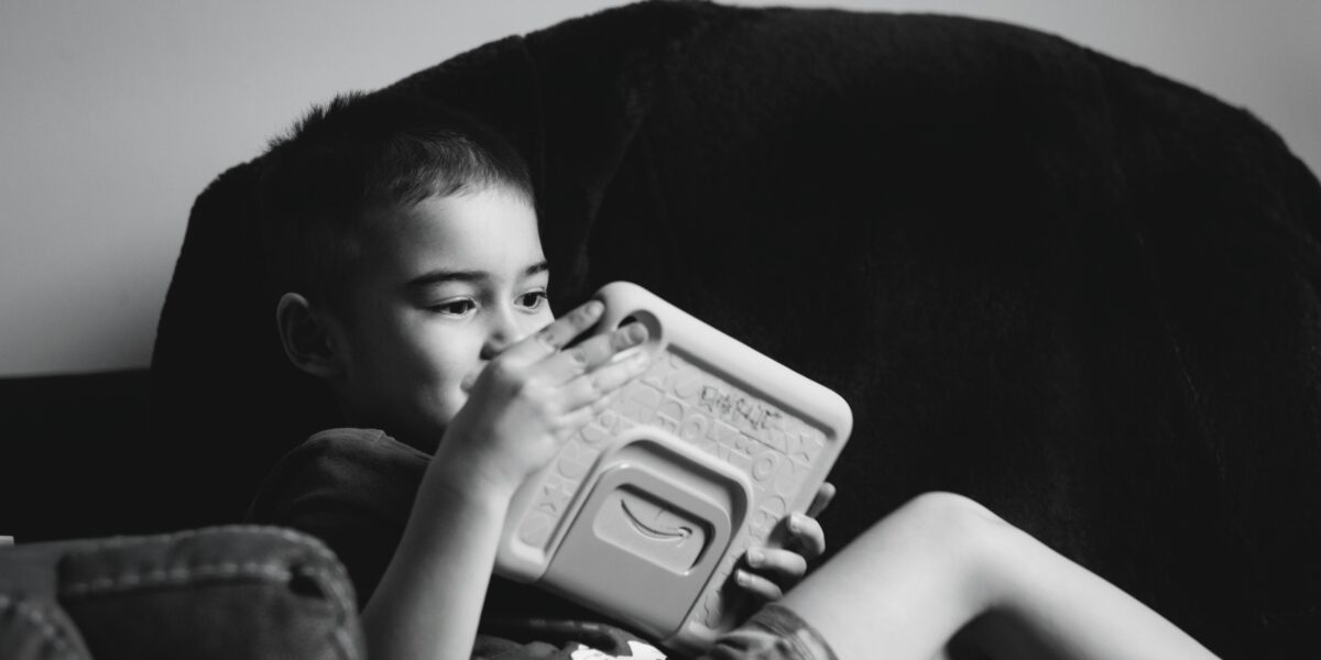 A young child engaged with a tablet device representing AI and cognitive development in children