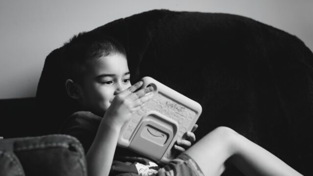 A young child engaged with a tablet device representing AI and cognitive development in children