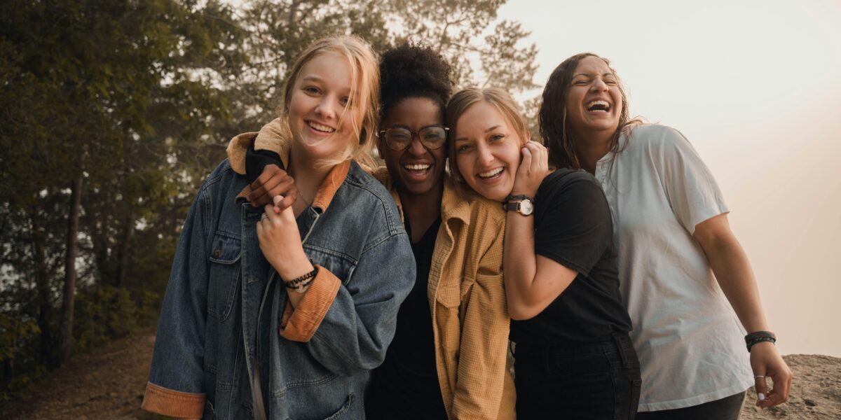 A diverse group of people smiling together, representing community wellbeing and happiness