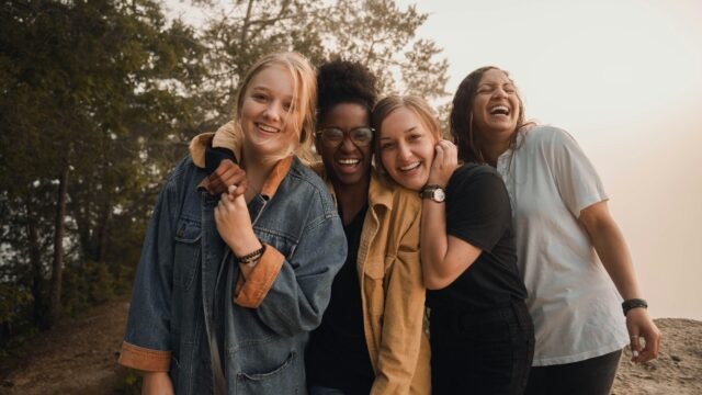 A diverse group of people smiling together, representing community wellbeing and happiness