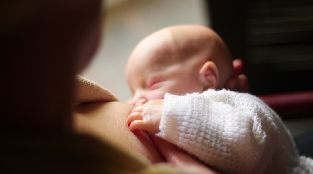 Mother breastfeeding her infant — the science behind breastfeeding and maternal health