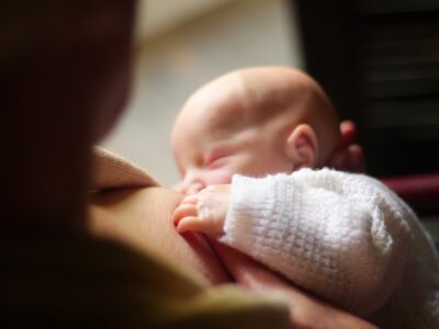 Mother breastfeeding her infant — the science behind breastfeeding and maternal health