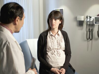 Obstetrician consulting a pregnant patient during antenatal checkup for preeclampsia